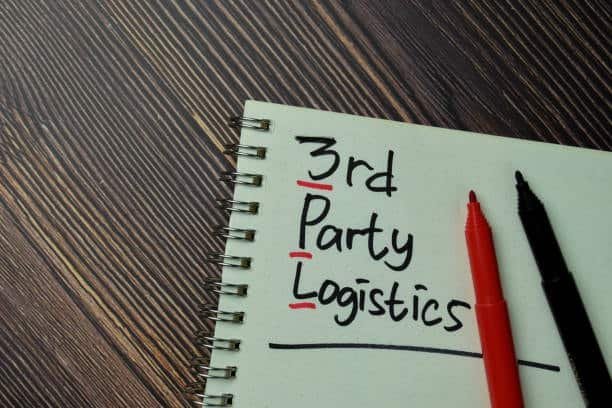 Notebook with the phrase “3rd Party Logistics” written beside red and black pens on wooden table