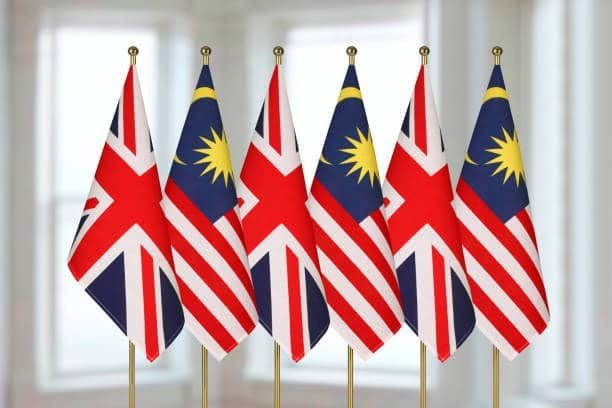 Row of alternating Malaysian and UK flags displayed indoors to represent trade partnerships