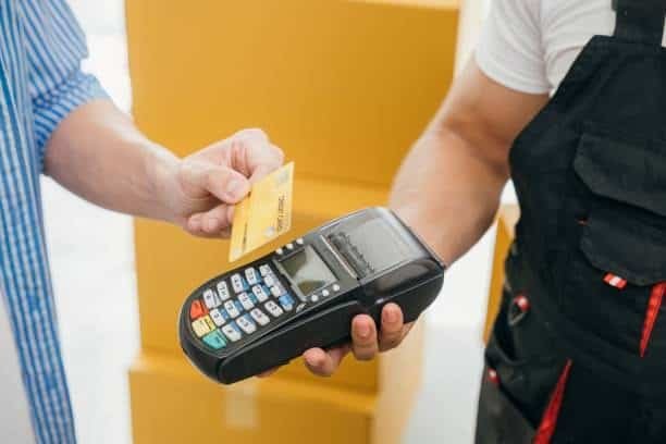 Person paying with a credit card for shipping or freight service at a logistics facility