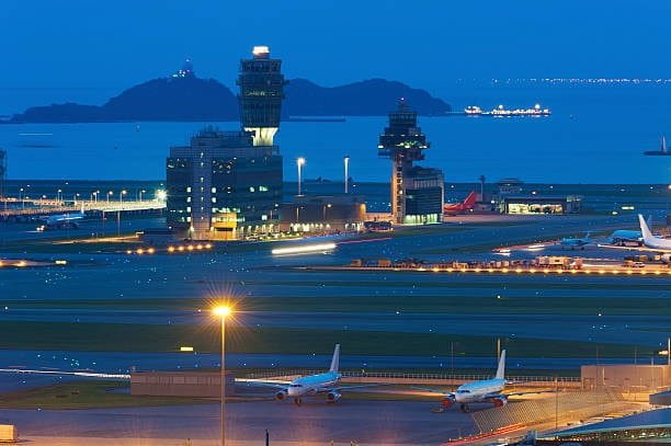 Night view of Chinese airport with cargo airplanes and control towers representing air freight logistics and international shipping