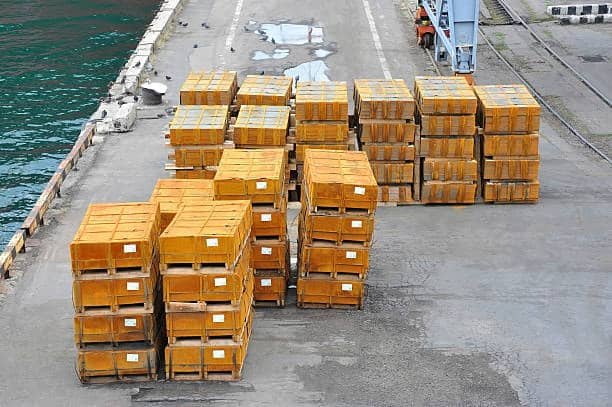 Stacked heavy crates on a loading platform near the water ready for freight loading