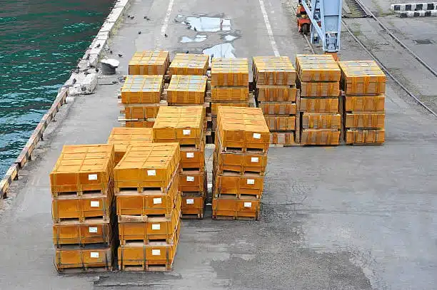 Stacked heavy crates on a loading platform near the water ready for freight loading