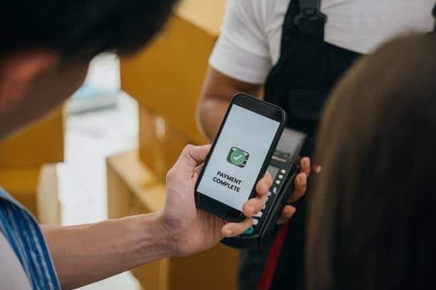 Close-up of phone screen showing "payment complete" at cargo delivery moment