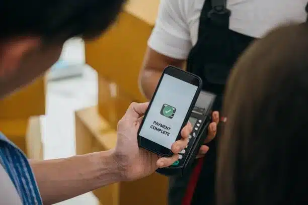 Close-up of phone screen showing "payment complete" at cargo delivery moment