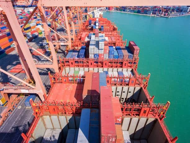 Aerial view of containers being loaded onto a ship at a German port, ready for export to the USA
