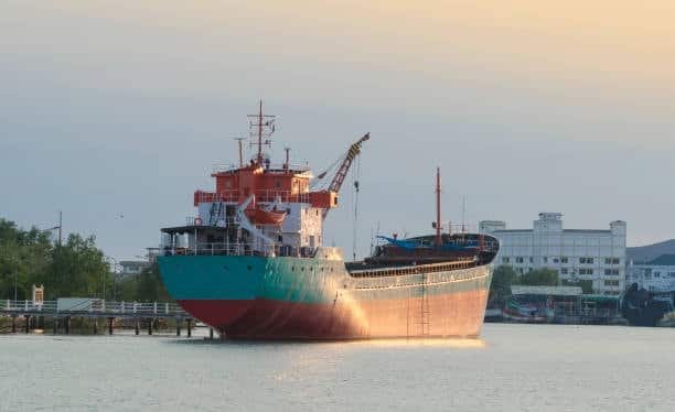 Freight ship ready to load goods at a coastal dock, used for large item transportation