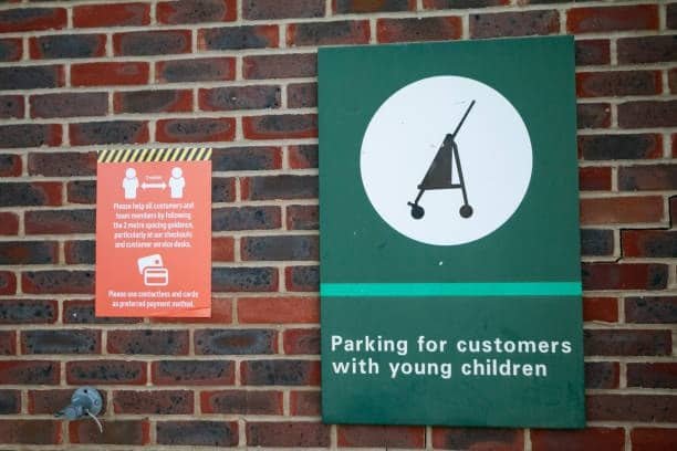 Brick wall signage showing designated parking spot for parents with children