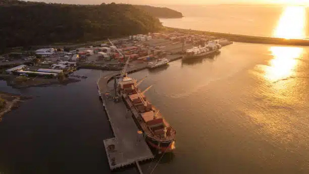 Sunset aerial view of Puerto Caldera shipping port in Costa Rica with cargo ships docked