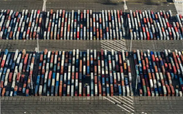 Aerial top view of shipping containers arranged in a large export yard
