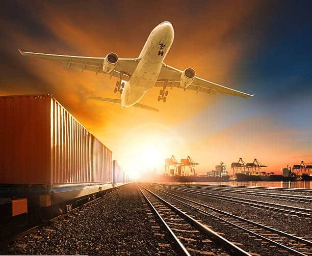 Cargo plane over railway and containers at dawn, showing time-sensitive freight from China to the UK