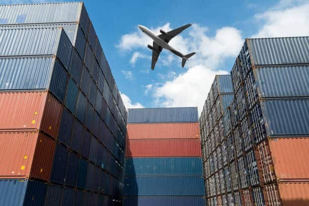 Airplane flying over stacked containers for global shipping from China to Sudan