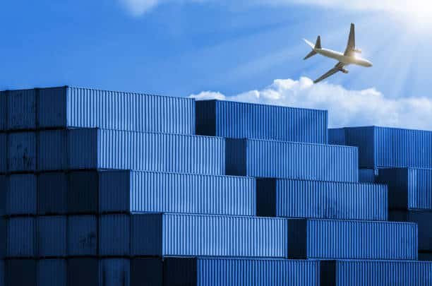 Airplane flying over stacked cargo containers, symbolizing air freight from China to Pakistan