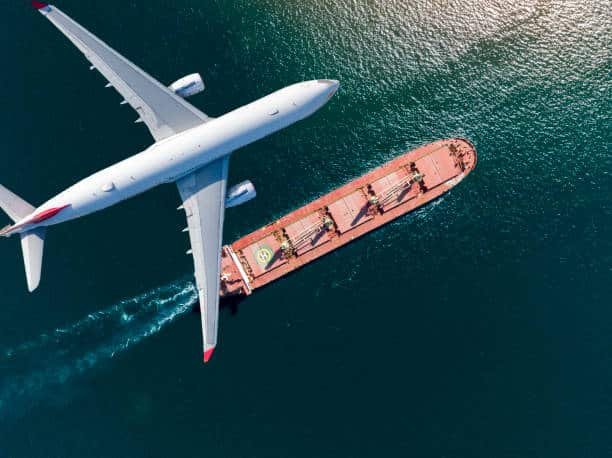 Aerial view of airplane flying over cargo ship en route from China to Venezuela