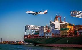 Airplane flying over container ship at port representing multimodal shipping from China to Laos.