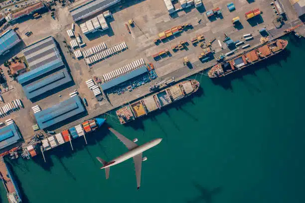 Top-down view of cargo port with airplane and docked vessels for China to Venezuela transport