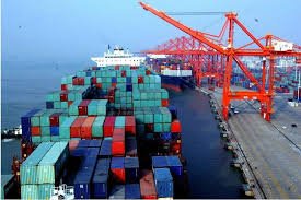 Large cargo vessel and port cranes loading containers for shipment from China to Malaysia.