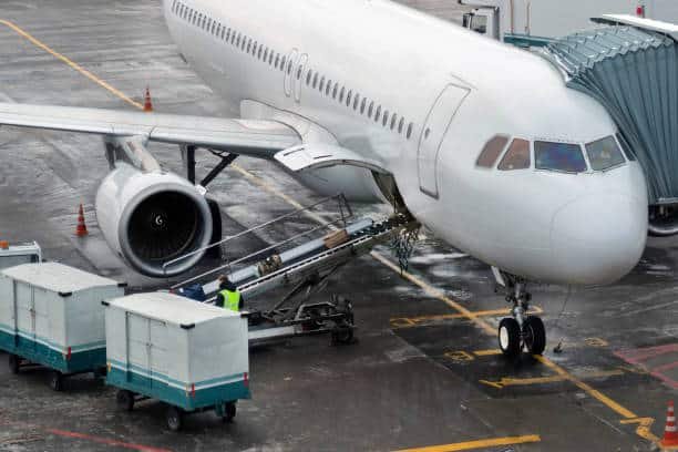 Ground crew loading cargo into an airplane at the dock
