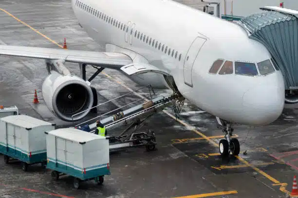 Ground crew loading cargo into an airplane at the dock