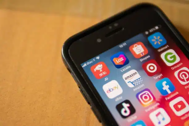 Smartphone showing app icons of Alibaba, JD, eBay, Amazon, and other e-commerce platforms