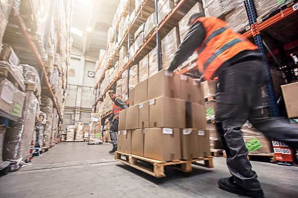Workers moving Alibaba freight boxes on pallet in warehouse aisle