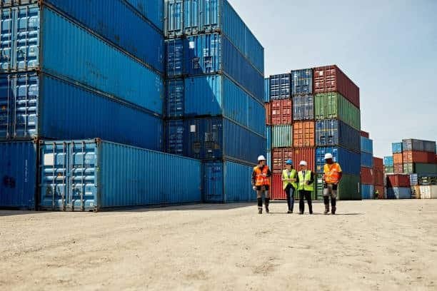 Stacked Alibaba shipping containers in yard awaiting transport
