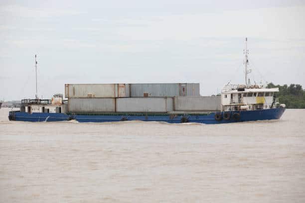 Small cargo vessel carrying containers for sea freight from China to the UAE.