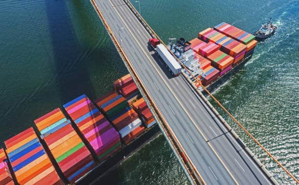 Freight truck and container ship transporting cargo across international borders
