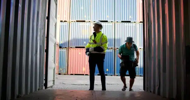 Logistic inspector checking cargo documentation inside a freight container