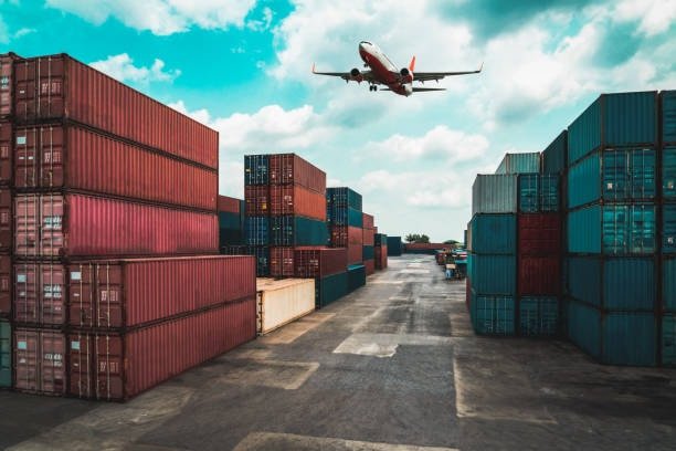 Cargo airplane over stacked shipping containers for international transport