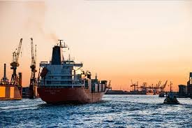 Cargo ship arriving at port during sunset, representing ocean freight from China to the Philippines