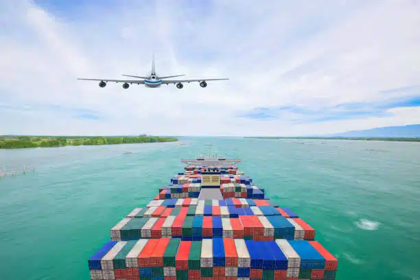 Airplane flying over container ship transporting goods from China to Kenya