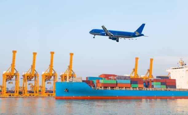 Container ship loaded with cargo and airplane in flight above cranes – represents multimodal shipping from China to Turkey.
