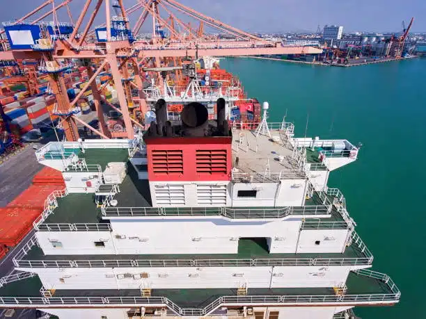 Loading containers into shipping vessel at port terminal