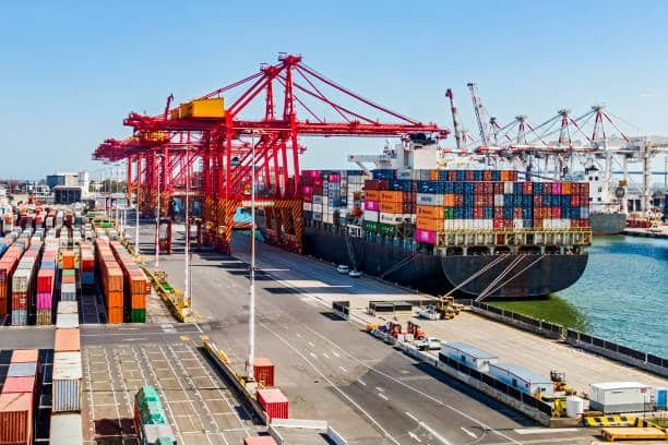 Shipping containers being loaded onto a vessel at a busy US port terminal