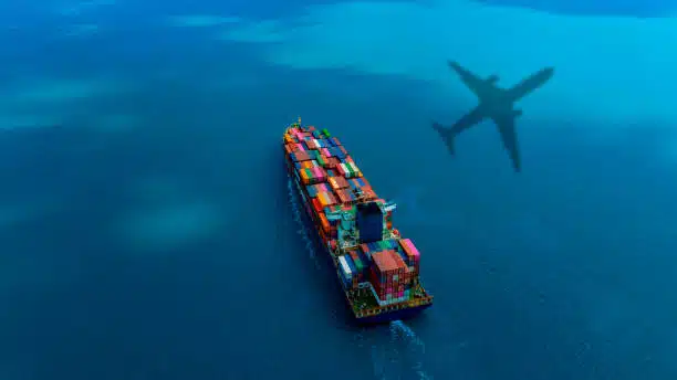 Aerial view of cargo vessel with airplane shadow, representing China to Belgium logistics route.
