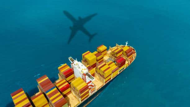 Aerial view of cargo ship with airplane shadow, illustrating logistics route from China to Mexico.