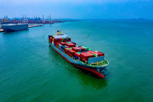 Full view of container vessel cruising in Singapore harbor