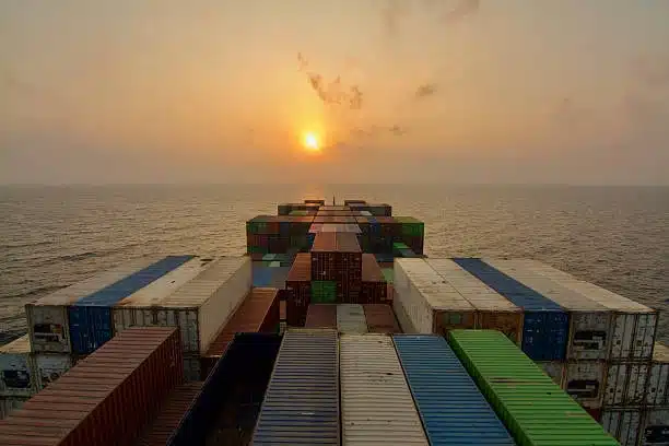 Colorful containers on a cargo ship at sea during sunrise representing TEU capacity