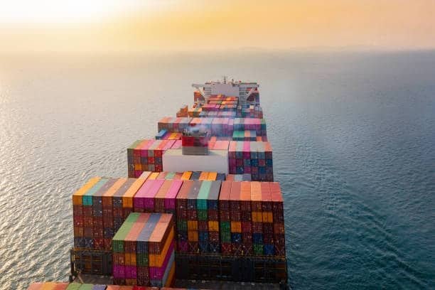 Aerial view of container ship loaded with multicolored containers at sea