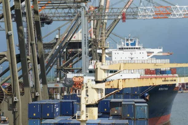 Container ship being loaded with freight at a busy Chinese port for shipment to UAE.