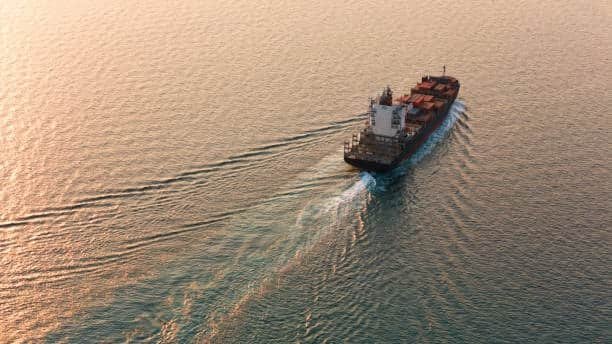 Cargo ship transporting freight across the sea as part of a global supply chain linked to inland drayage operations.