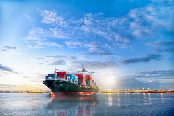 Cargo ship loaded with containers sailing from China to Brazil under clear sky