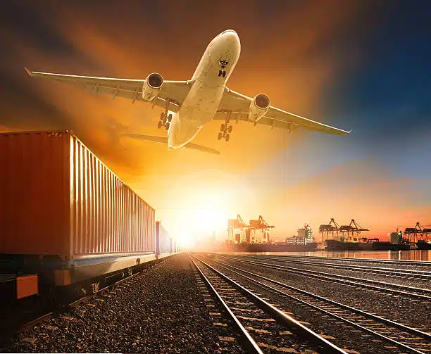 Airplane taking off over freight train and shipping containers at sunrise, symbolizing fast logistics from China to the UK