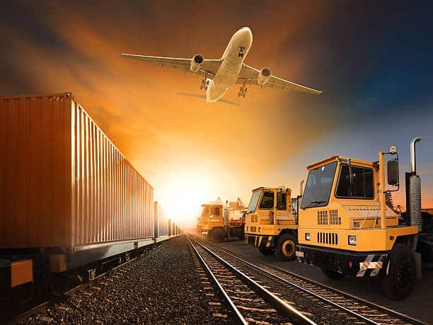 Airplane flying over container train and yellow cargo trucks at sunrise representing fast logistics to Cameroon