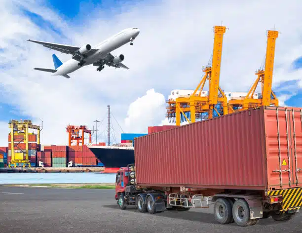 Container truck and airplane operating near seaport cranes, illustrating multimodal shipping to Pakistan