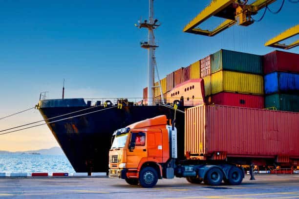 Container truck loading goods at port for delivery to Italy