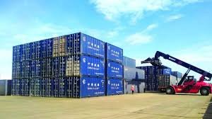 Shipping containers stacked in a yard, ready for export from China to Laos.