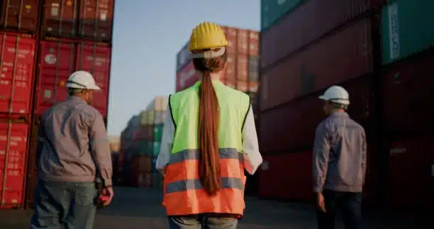 Logistics team walking through a container yard for cargo inspection