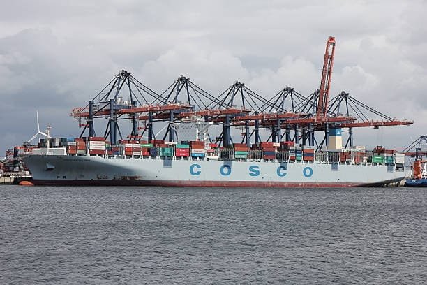 COSCO vessel at port with cranes loading TEU containers for export