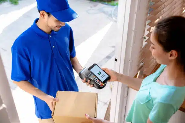 Door-to-door courier collecting digital signature during package delivery